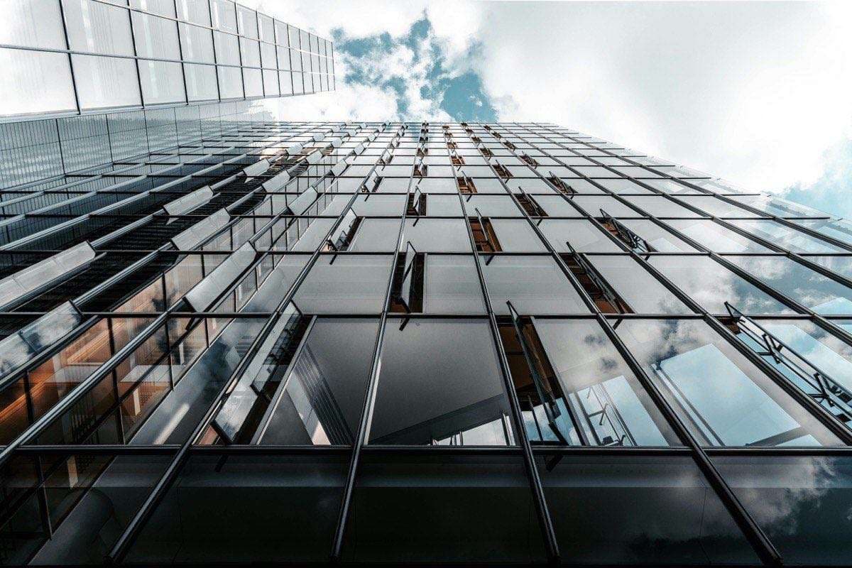 Glass curtain wall facade looking upward at a modern commercial building